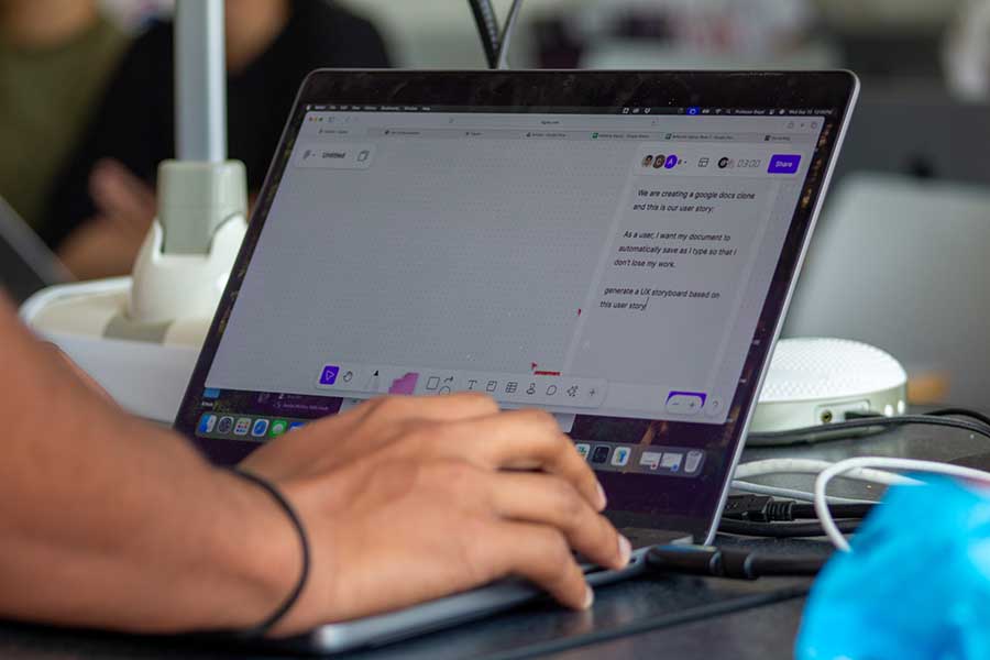 A close up of hands working on a laptop.