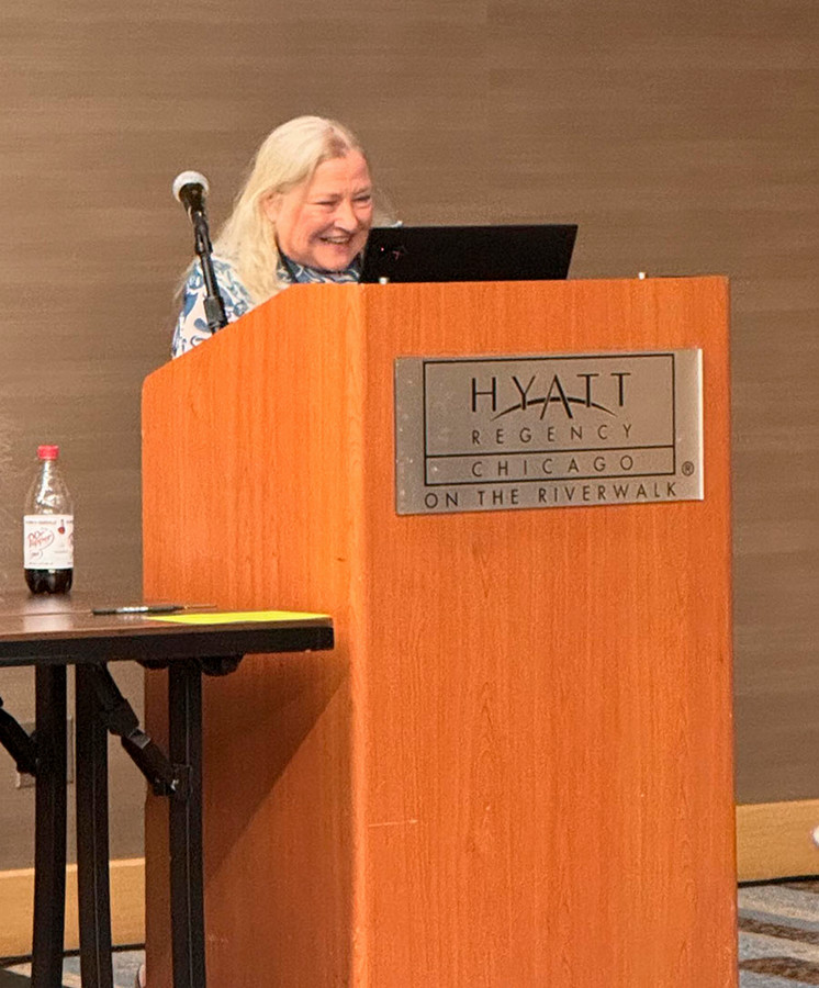 A woman stands behind a lectern.