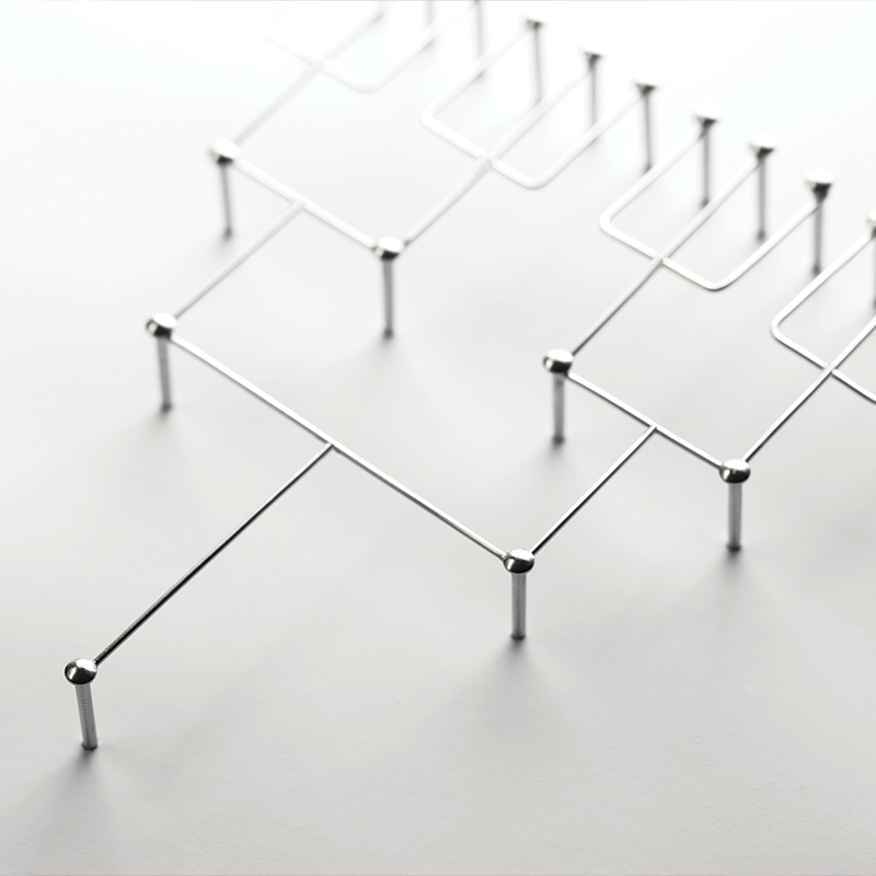 silver pins in a white seamless paper, silver metal thread attaching each of the pins as they spread out into a binary tree structure